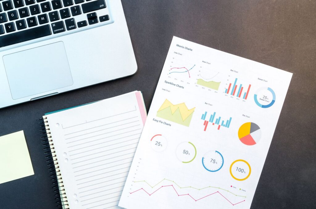Analytics reports and charts on a desk with a laptop